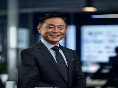 探花视频在线观看创始人张伟的工作照，身着深色正装在现代化办公室中微笑，背景为展示平台数据的大屏幕，神情自信从容